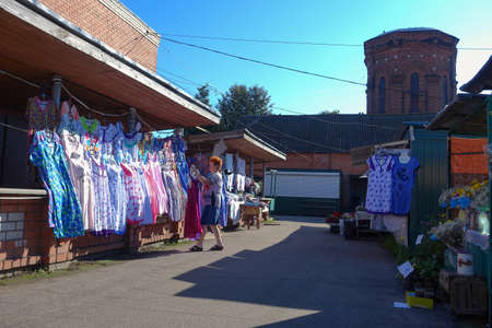Woman hangs colored nightgowns and robes in the bazaar-market for saleの写真素材