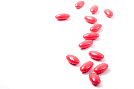 May red pills lay on white backgroundの写真素材