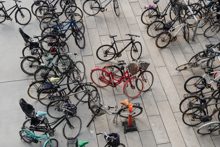 a red bicycle in the middle of many black bicycles.の写真素材