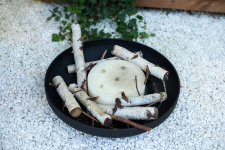 Metal black fireplace bowl in garden on back yard lawn. Patio fire steel pit round fireplace appliance for outdoor party. Iron rounded fire pit on backyard party place. Fire pit and fireplaceの写真素材