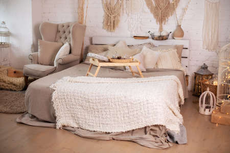 Stylish room interior with large bed and wooden coffee table. Cozy atmosphere in loft style.の写真素材