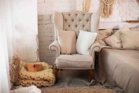 Stylish interior of living room with comfortable armchair and knitted blanketの写真素材