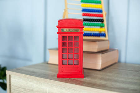 Figurine of a red telephone booth on shelf. Mini figurine of London Telephone Booth for sale as souvenir. telephone booth present. Red british phone booth statuette decoration room.の写真素材
