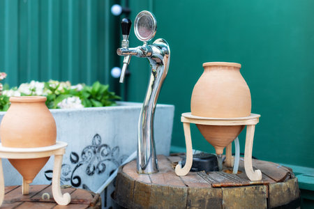 Georgian traditional decorative jugs for wine qvevri. Vintage georgian wine jugs. Clay jugs used to decorate the cafe. Bar counter and taps to tap beer on street cafe.の写真素材