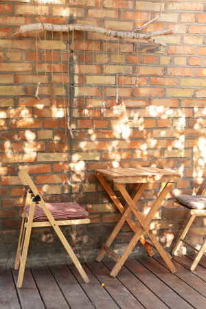 Empty street coffee shop with wooden terrace and brick wall. Wooden chairs and table in outdoor...