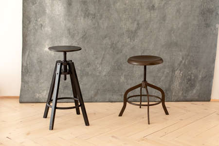 black minimalist metal chairs against gray background. Concept modern interior and design furniture...