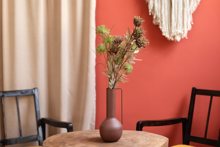 On wooden table are a vase of flowers in the room. Cozy scandinavian home decor. Living room composition with pink wall and stylish minimalist home accessories on wooden tableの写真素材