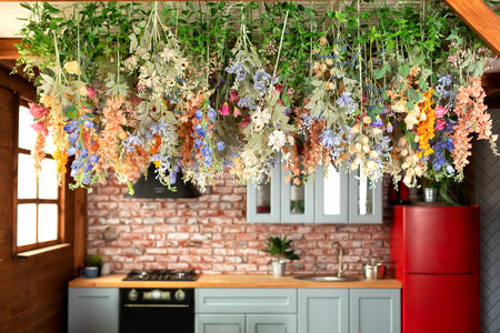 Cozy room decorated with summer floral decor. Interior Kitchen with Composition colorful wildflowers and plant hanging on wall. Wooden blue kitchen with furniture, stoveの写真素材