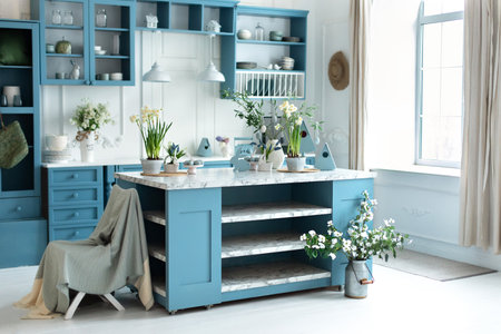 Wooden kitchen in east decor. Kitchen utensils and plate on table. kitchen island in dining room. Blue kitchen interior with furniture. Stylish cuisine with flowers in vaseの写真素材