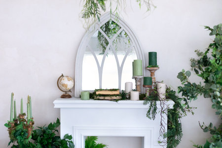 White fireplace with green plants and candles. Interior of a modern houseの写真素材