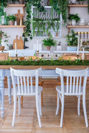 White chairs and table in the interior of a cozy restaurant with plantsの写真素材