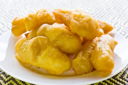 Beautiful deep-fried doughstick closeup on dishの写真素材