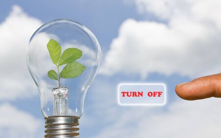 A hand presses a virtual button turn off energyの写真素材