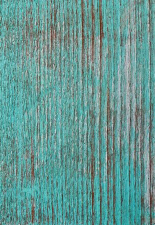 Green paint peeling from a wooden panel door showing the wood grainの写真素材