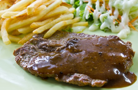 Steak with fresh vegetables salad and french friesの写真素材