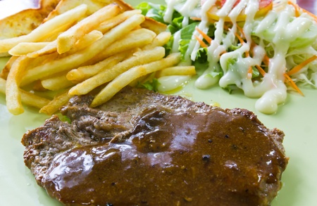 Steak with fresh vegetables salad and french friesの写真素材