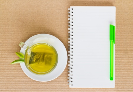 Green tea in a white cup on a paper backgroundの写真素材