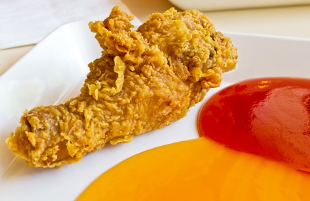 Fried chicken legs served with  tomato sauce and chili sauceの写真素材