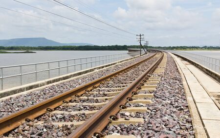 Railroad tracks curving  across the lakeの写真素材