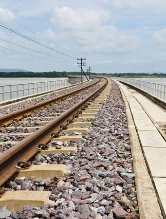 Railroad tracks curving  across the lakeの写真素材