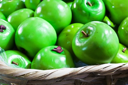 Fake green apple in basketの写真素材