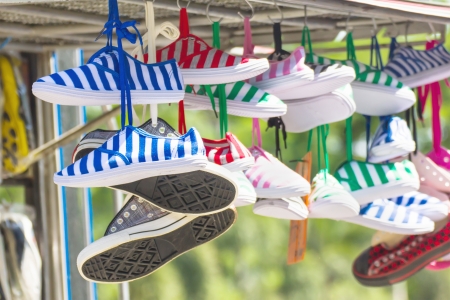 Lot of sneakers   shoes multicolored hanging on roofの写真素材