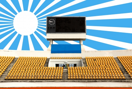 Rows of orange seats on the stadium with scoreboard displaying clock above them and sun rayのeditorial素材