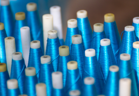 Bobbin for weaving silk,Spool of blue silk thread in rowの写真素材