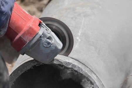 Plumbers cutting concrete water pipes by metal grindingの写真素材