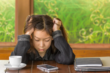 Girl has a headache, Girl with a headache while sitting at deskの写真素材