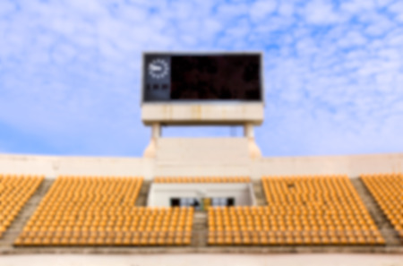 Blurred the stadium with scoreboard displaying clock above themの写真素材