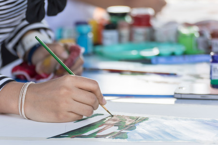 Close-up of Hand with brush and paint by watercolorsの写真素材