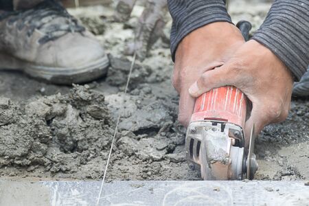Mason cutting tiles to repair by metal grindingの写真素材