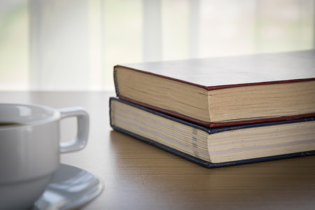 Book and Cup of coffee on wood table and red book