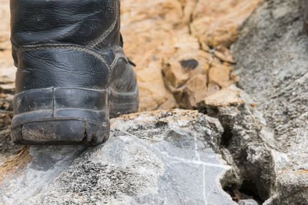 Closeup of trekking leather boot on the rock in mountainの写真素材
