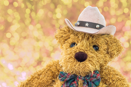 Close up cowboy teddy bear with yellow bokeh backgroundの写真素材
