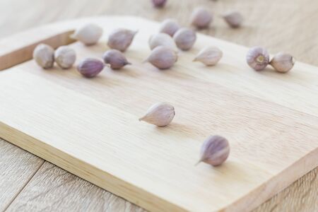 Garlic on wood cutting board and wood table from aboveの写真素材