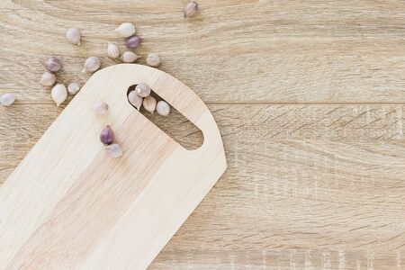 Top view Garlic on wood chopping board and wood table from aboveの写真素材