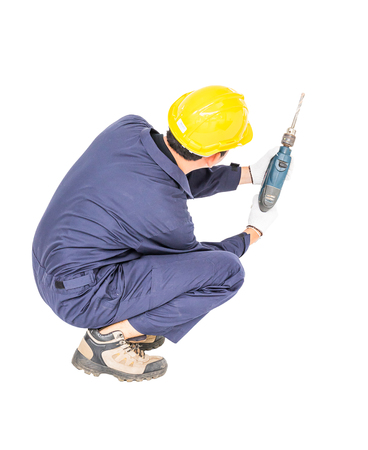 Young handyman in unifrom standing with his electric drill, Cutout isolated on white backgroundの写真素材