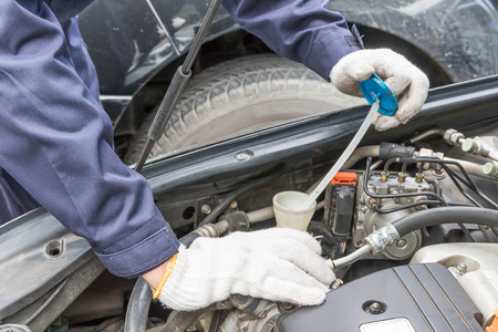 Auto mechanic check engine car at work in his garageの写真素材