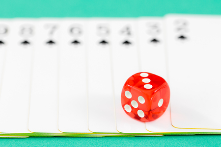 Red dices and cards on green casino table, Gambling is illegal.の写真素材