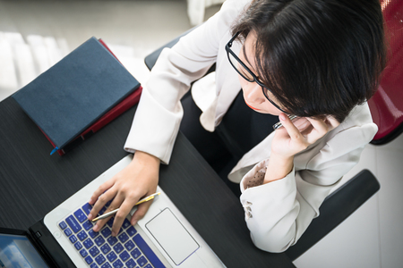 Young asian woman short hair in smart casual wear working on laptop in home officeの写真素材
