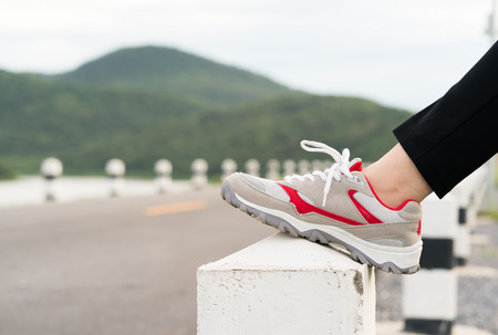 Woman runner doing exercises and warm up preparing for jogging outdoorの写真素材