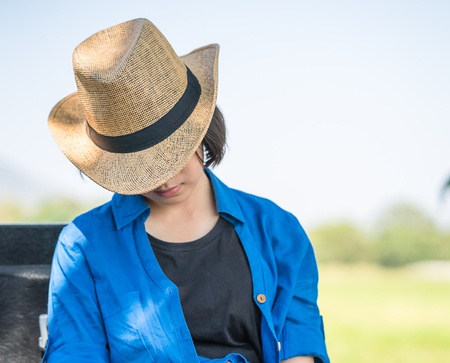 Young asian women short hair wear hat sit sleep in countryside Thailandの写真素材