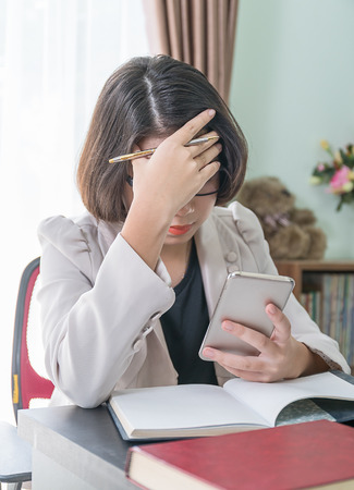 Teenage girl short hair in smart casual wear working on laptop while sit near window at home officeの写真素材