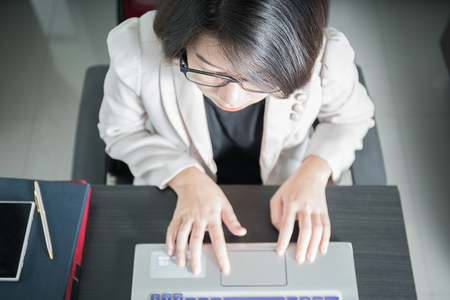 Young asian woman short hair in smart casual wear working on laptop in home officeの写真素材