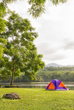 Tourist dome tent camping in forest camping site at lake sideの写真素材