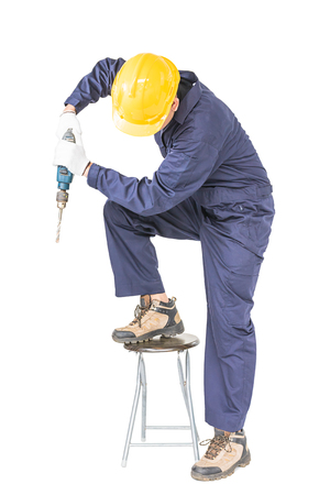 Young handyman in unifrom standing with his electric drill, Cutout isolated on white background with clipping pathの写真素材
