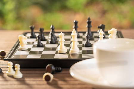 Cups of coffee on wood table with Chess board and pieces for relax timeの写真素材