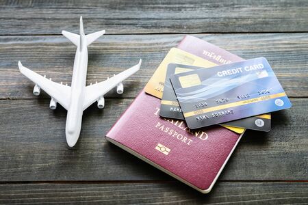 Passport with  credit card on brown wooden desk background, Preparation for Traveling conceptの写真素材
